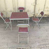 Square card table and four folding chairs set, arranged outdoors to show full set and condition