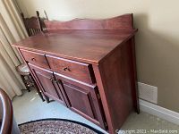 Side view of wooden sideboard showing drawer and cabinet doors.