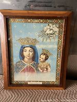 Full frontal view showing the framed religious print of Madonna and Child with stars and decorative border.