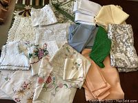 Box of assorted assorted vintage linens and napkins showing detailed embroidery, lace, crochet, and prints