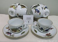 10 Royal Worcester Evesham cups and saucers stacked and displayed, showing fruit and leaf pattern and gold trims.