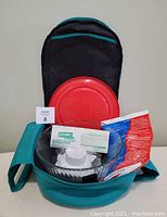 Open insulated teal bag showing 4.5 quart glass bowl with red lid, gel pack and dividers inside.