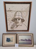 Frontal view showing all three framed artworks placed together: large crewel embroidery (top), watercolour (bottom left), photograph (bottom right).