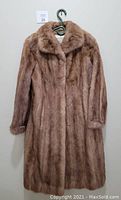 Front view of the vintage mink fur coat showing full length and collar style, hung on hanger.
