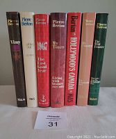Front view of seven Pierre Berton hardcover books aligned upright showing titles on spines with dust jackets.
