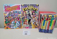 Photo showing 2 Archie Americana Series comic books Best of the Eighties and Best of the Eighties Book 2 alongside a stack of 10 comic books including World of Archie, Jughead, Betty and Veronica annuals, and digests.