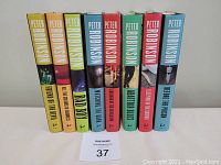 Front view of eight Peter Robinson hardcover novels with colorful dust jackets, spines showing titles and author's name, arranged standing vertically.