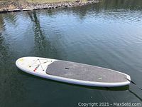 Stand up paddleboard afloat on water showing board shape and traction pad