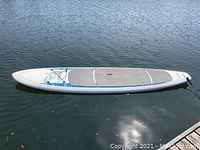Full length of SUP board floating on water showing shape and profile