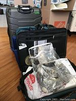 Overall view of the luggage pieces stacked and storage bin with curtain hardware bag on top.