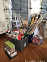 Bins filled with various gift bags, gift boxes, and multiple rolls of gift wrapping paper.