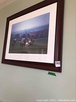 Full view of framed art print showing horses and jockeys with British countryside background