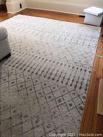 Angled view showing full rug on hardwood floor with corner of sofa.