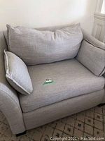 Front view of light gray chair and a half featuring back cushion, side pillows and removable seat cushion with lot tag