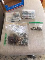 Top view of assorted jewelry packed in plastic boxes and zip-lock bags including 925 stamped pieces.
