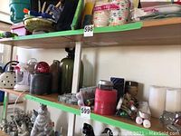 Shelf with candles, ceramic jugs, and other kitchenware items including Proctor Silex juicer
