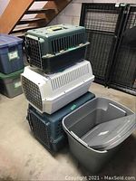 Stacked view of the three different sized plastic pet carriers with metal wire front doors, showing wear and tear.