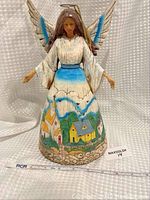 Heart Creek Jim Shore Angel figurine, showing full front view with village scene skirt and wing details.