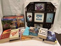 Mixed lot displayed showing books, puzzles, and picture frame arranged together.