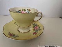 Side angle view of EB Foley china cup on matching saucer showing floral pattern and gold trim