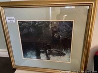 Image showing frontal view of framed print featuring loon and chick on water with gold frame and double matting.