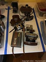 Lot overview showing six vintage cameras including Kiev 303 with leather case and box, Kodak Retina, Kodak Flash Bantam flash, Agfa Computer Rapid, Foldex 20, and Zorki 4.