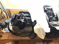 Wide view showing Nikon Coolpix 995 camera, Olympus E-500 camera, carrying bag and lenses on wooden table.