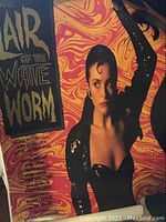 Close-up of the "Air of the White Worm" movie poster showing woman and text against psychedelic background