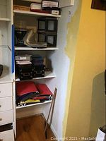 Shelf with hanging file folders, black storage boxes, and other items