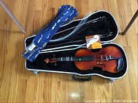 Open case showing violin, bow and strings pack inside