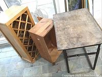 Photo showing all three items: vintage school desk, wooden wine rack cabinet, and wooden crate with lid, placed on tiled floor near window.