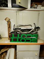 Multiple bike handlebars stacked on green Scott branded box on shelf