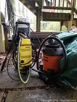 Overall view of Karcher pressure washer and Shop-Vac wet/dry vacuum outdoors on concrete floor