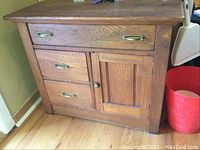 Image of wooden cabinet showing front view with three drawers and door, highlighting metal handles and wooden drawers