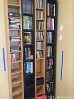 Photo of multiple shelving units containing various CDs, DVDs, and VHS tapes arranged vertically