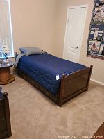 Overall assembled twin bed frame with bedding in bedroom setting