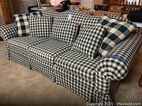 Whole sofa bed in plaid upholstery with matching pillows, showing overall look and style