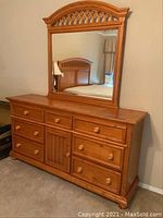 Front view of two-piece wood dresser and mirror in bedroom setting