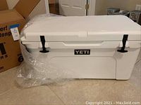 White YETI Tundra 65 cooler in plastic wrap, closed lid