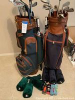 Front view of both Lancer golf club sets in carry bags with accessories on floor