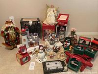 Wide view of entire Christmas collectibles lot including Santa wreath figure, lighthouse, snowmen, angel, and boxed ornaments
