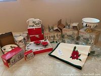 Photo showing assortment of Christmas serveware including mugs, bowls, glasses, and platter with needlepoint table runner.