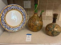 Set of hand painted Italian ceramic platter with two decorative glass wine decanters wrapped in old world map design.