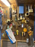Photo of assorted hanging garden and painting tools fixed on pegboard, showing the overall assortment and layout.