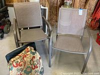 Two metal frame patio chairs with mesh seats and backs shown in garage space with cushions in front.