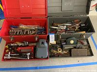 Two open tool boxes displayed with assorted tools inside, showing the full contents of each box.