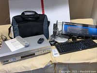 Overall view showing laptop case, VCR, flip phone, cordless phones, keyboard