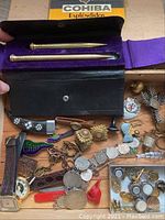 Photo showing two vintage pens in a black case with purple velvet lining and assorted men's vintage items around