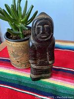 Photo of the front of the soapstone carving showing the carved Inuit figure with traditional clothing details.