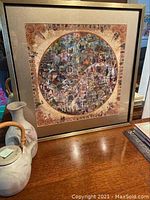 Framed square art print on a wooden surface, showing the full piece and frame.